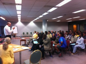 Co-facilitators Jim Boucher (standing) and Linda Bayer (sitting, bottom left) leading the group in a lively discussion about the Neighborhood Place.