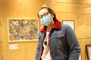 Jhade Claure, of East Hartford, stands next to her piece "The American Boo Boo Dream" on display at Hartford Public Library's Downtown Library.